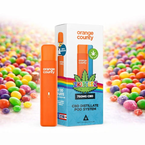 Orange County - CBD Vape Pen 1ml Pod 750mg in vordergrund, umgeben von bunten Süßigkeiten.